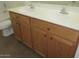 Bathroom with double vanity and wood cabinets at 43624 W Bailey Dr, Maricopa, AZ 85138
