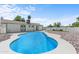 Inviting kidney-shaped pool with a relaxing rock and artificial turf landscaping at 6802 E Beverly Ln, Scottsdale, AZ 85254