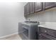 Laundry room with washer, dryer, and dark brown cabinets at 26496 W Lone Cactus Dr, Buckeye, AZ 85396