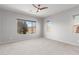 Bright bedroom with neutral walls, carpet flooring, and a ceiling fan at 26496 W Lone Cactus Dr, Buckeye, AZ 85396
