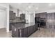 Modern kitchen with dark cabinets, stainless steel appliances, and granite countertops at 26496 W Lone Cactus Dr, Buckeye, AZ 85396