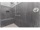 Large walk-in shower with gray tile and built-in seat at 26496 W Lone Cactus Dr, Buckeye, AZ 85396