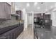 Modern kitchen with dark cabinets, a large island, and mosaic backsplash at 26496 W Lone Cactus Dr, Buckeye, AZ 85396