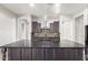 Modern kitchen with a large island, dark cabinetry, and a mosaic backsplash at 26496 W Lone Cactus Dr, Buckeye, AZ 85396