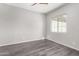 Simple bedroom with hardwood floors and a ceiling fan at 26496 W Lone Cactus Dr, Buckeye, AZ 85396