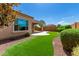 Artificial turf backyard with a covered patio and shrubs at 26496 W Lone Cactus Dr, Buckeye, AZ 85396