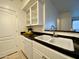 White kitchen with double sink, black countertop, and glass cabinets at 1701 E Colter St # 472, Phoenix, AZ 85016