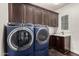 Laundry room with modern washer and dryer, cabinets and sink at 10803 E Ramblewood Cir, Mesa, AZ 85212