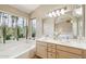 Elegant bathroom with double sinks, soaking tub, and large windows at 617 S Paradise Dr, Gilbert, AZ 85233