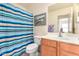 Clean bathroom with striped shower curtain and updated vanity at 2420 W Blue Sky Dr, Phoenix, AZ 85085