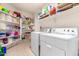 Laundry room with washer, dryer, and ample storage shelves at 2420 W Blue Sky Dr, Phoenix, AZ 85085