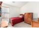 Charming bedroom with a red bedspread and antique dresser at 2420 W Blue Sky Dr, Phoenix, AZ 85085