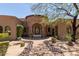 Elegant home with a stone facade, arched entryway, and a beautifully landscaped front yard at 8157 E Sierra Morena St, Mesa, AZ 85207