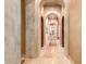 Elegant hallway with arched doorways and a beige stone floor at 8157 E Sierra Morena St, Mesa, AZ 85207