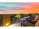 Peaceful patio with chairs and tables overlooking city lights at sunset at 8157 E Sierra Morena St, Mesa, AZ 85207