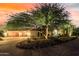 Stunning home with a beautiful landscaped yard, three-car garage, and dramatic desert sunset at 8157 E Sierra Morena St, Mesa, AZ 85207