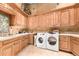 Laundry room with wooden cabinets, washer, and dryer at 8157 E Sierra Morena St, Mesa, AZ 85207