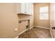Laundry room with built-in cabinets and tile flooring at 12840 W Santa Ynez Dr, Sun City West, AZ 85375