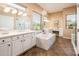 Spa-like bathroom with double vanity and soaking tub at 12840 W Santa Ynez Dr, Sun City West, AZ 85375
