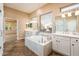 Elegant bathroom featuring a large soaking tub and double vanities at 12840 W Santa Ynez Dr, Sun City West, AZ 85375
