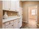 Bright laundry room with white cabinets and quartz countertops at 12840 W Santa Ynez Dr, Sun City West, AZ 85375