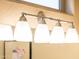 Four-light vanity fixture with frosted glass shades above the bathroom mirror at 12840 W Santa Ynez Dr, Sun City West, AZ 85375