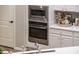 Built-in microwave and oven with white shaker cabinets and quartz countertops at 12840 W Santa Ynez Dr, Sun City West, AZ 85375