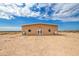 Tan metal building exterior with double doors and desert landscaping at 35203 W Indian School Rd, Tonopah, AZ 85354