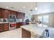 Spacious kitchen with granite countertops and dark wood cabinets at 40350 W Art Pl, Maricopa, AZ 85138