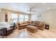 Living room with sectional sofa, ottoman, and ceiling fan at 40350 W Art Pl, Maricopa, AZ 85138