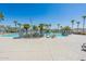 Community pool with lounge chairs and palm trees at 40350 W Art Pl, Maricopa, AZ 85138