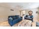 Living room with two sofas, ottoman, and view into kitchen at 40350 W Art Pl, Maricopa, AZ 85138