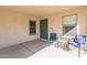Inviting front porch with two blue chairs and a small table at 40350 W Art Pl, Maricopa, AZ 85138