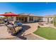 Relaxing patio with seating area, fire pit, and red umbrella at 40350 W Art Pl, Maricopa, AZ 85138