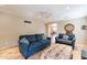 Living room with two sofas, ottoman, and view into kitchen at 40350 W Art Pl, Maricopa, AZ 85138