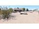 Large backyard with dirt, sparse vegetation, and a log at 23208 W Gloria Ln, Wittmann, AZ 85361