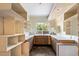 Simple kitchen with wood cabinets, a large window, and ample shelving at 13017 N 61St Pl, Scottsdale, AZ 85254