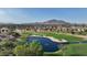Aerial view showcasing a golf course community, featuring homes and a serene lake at 6574 S Crestview Dr, Gilbert, AZ 85298