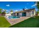 Large backyard with a beautiful pool and grassy area at 7740 E Rose Ln, Scottsdale, AZ 85250