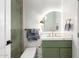 Modern bathroom with green vanity and gold fixtures at 7740 E Rose Ln, Scottsdale, AZ 85250