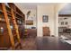 Home office with built-in shelves, ladder, and view into living room at 4755 S Pura Vida Way, Gold Canyon, AZ 85118