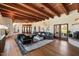 Open living area with hardwood floors, a sectional sofa, and wood beam ceilings at 23832 N 112Th Pl, Scottsdale, AZ 85255