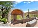 Covered outdoor fireplace with brick detailing and desert mountain views at 23832 N 112Th Pl, Scottsdale, AZ 85255