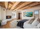 Main bedroom with wood beam ceiling, fireplace and large windows with scenic views at 23832 N 112Th Pl, Scottsdale, AZ 85255