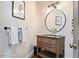 Stylish powder room with wood vanity and a large round mirror at 23832 N 112Th Pl, Scottsdale, AZ 85255