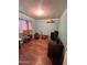 Third bedroom with wood-look floors, brick walls, and a desk at 6321 N 65Th Dr, Glendale, AZ 85301