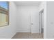 Simple bedroom with carpet, window, and door to another room at 17975 W Vogel Ave, Goodyear, AZ 85338