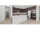 Modern kitchen featuring dark cabinets, a large island, and stainless steel appliances at 17975 W Vogel Ave, Goodyear, AZ 85338