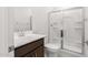 Clean bathroom featuring a shower, toilet and vanity with brown cabinets at 17975 W Vogel Ave, Goodyear, AZ 85338