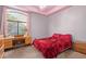 Bedroom with red bedding and a built-in desk at 6918 E Granada St, Mesa, AZ 85207